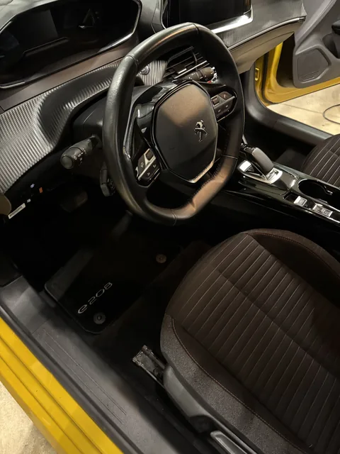 Volant Peugeot 208 jaune avec intérieur impeccable après detailing Presticar