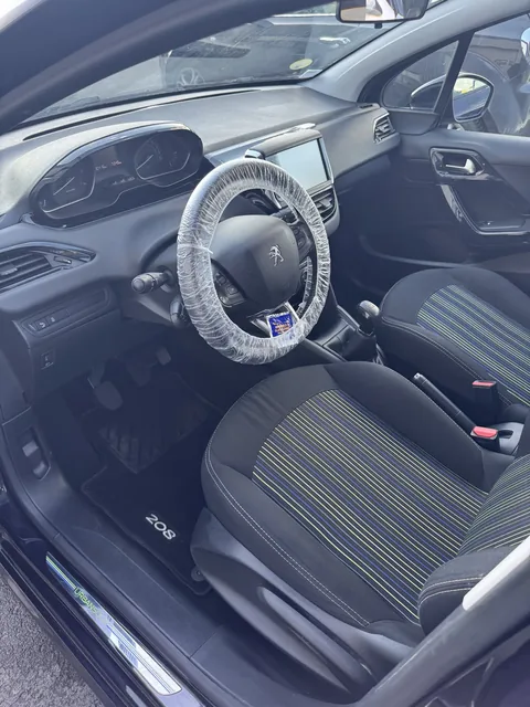 Intérieur Peugeot 208 noir et jaune nettoyé après prestation Presticar